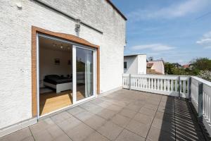 a large sliding glass door on a balcony with a couch at AM01 Haus mit Garten & Terrasse! in Groß-Gerau