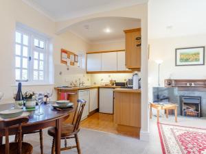 een keuken en eetkamer met een tafel en een open haard bij 2 Bed in Holsworthy 77555 in Black Torrington