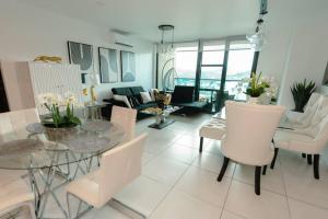 sala de estar con mesa de cristal y sillas blancas en Luxury 3BR Penthouse in Astria 1408, en Tegucigalpa