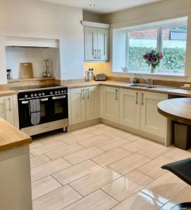 a kitchen with white cabinets and a wooden floor at The Graph’s Gaff 