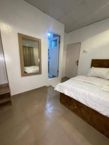 a bedroom with a large bed and a mirror at MPH in Lagos