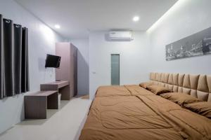a bedroom with a large bed and a tv at พลอยพูลวิลล่า ชะอำ 1 Ploy Poolvilla Cha-am 1 in Cha Am