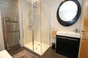 a bathroom with a shower and a sink and a mirror at Luxury Detached Home Close to Strangford Lough in Killinchy +24 photos