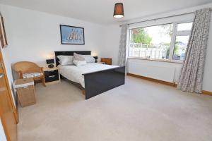 a bedroom with a bed with a desk and a window at Luxury Detached Home Close to Strangford Lough in Killinchy