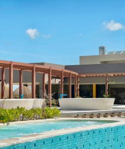 a resort with a swimming pool in front of a building at Apec Mandala Mũi Né - Phan Thiết in Phan Thiet