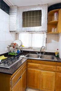 een keuken met een wastafel, een fornuis en een raam bij Acogedor Loft Laguito 1 Habitacion N in Cartagena