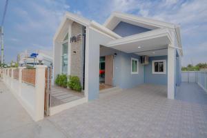 una piccola casa blu e bianca con portico di พลอยพูลวิลล่า ชะอำ 1 Ploy Poolvilla Cha-am 1 a Petchaburi