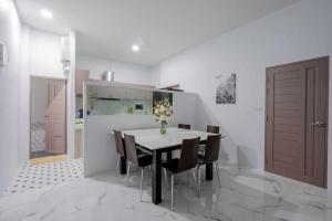 a kitchen with a dining room table and chairs at พลอยพูลวิลล่า ชะอำ 1 Ploy Poolvilla Cha-am 1 in Cha Am
