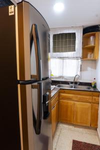 een roestvrijstalen koelkast in een keuken met houten kasten bij Acogedor Loft Laguito 1 Habitacion N in Cartagena