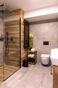 een badkamer met een douche, een toilet en een wastafel bij APartament Piaskowa in Gniewino