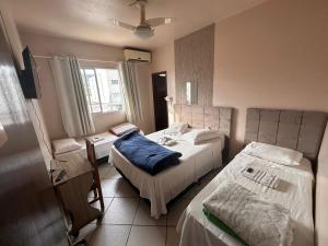 um quarto de hospital com duas camas e uma janela em HOTEL Rafael em Bom Retiro