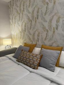 Una cama con almohadas en ella y una pared en Céntrico Estudio en Formigal - Recién Reformado, en Formigal