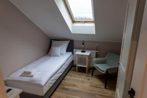 niewielka sypialnia z łóżkiem i oknem w obiekcie APartament Piaskowa w mieście Gniewino