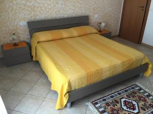 a bedroom with a bed with a yellow blanket on it at Dall'Orso Grigio in Balestrate
