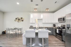 a kitchen with white cabinets and a kitchen island with stools at Shades of Grey in Houston