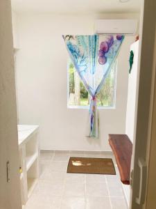 um quarto com uma janela com uma cortina em GREEN PARADISE LEONA VICARIO em Leona Vicario