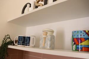 a white shelf with cups on it in a kitchen at Naples Soul - city center in Naples