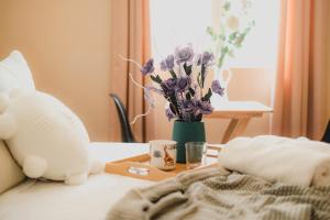 uma mesa com uma bandeja com um vaso de flores roxas em Miraflores Private Rooms - Guest House - Cocina Compartida - Terraza em Lima
