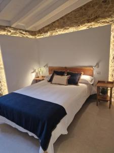 a bedroom with a large bed with a blue blanket at A casa d'abaixo in Parada del Sil