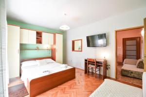 a bedroom with a bed and a desk and a television at PETAR in Baška Voda