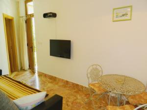 a living room with a table and a tv on a wall at PETAR in Baška Voda