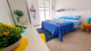 Un dormitorio con una cama azul con toallas. en Gaeta in Vacanza - Esclusivo App. sulla Spiaggia, en Gaeta