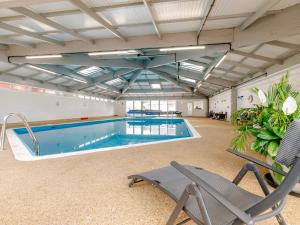 a large swimming pool in a building with a chair at 3 Bed in Millbrook 83792 in Millbrook