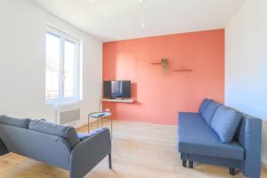 een woonkamer met 2 stoelen en een blauwe bank bij Appartement Calme - Arras Arrière Gare in Arras