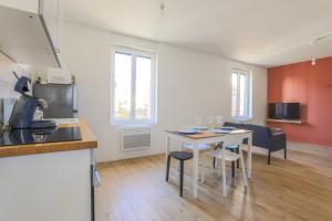 een keuken en een woonkamer met een tafel en stoelen bij Appartement Calme - Arras Arrière Gare in Arras