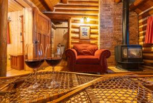 two glasses of wine on a table in a room with a fireplace at Storm Mountain Lodge & Cabins in Banff