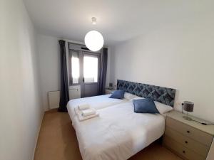 a bedroom with two beds and a window at Gestiona2R - Apartamento Lita in Posada de Llanes