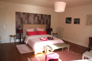 een slaapkamer met een groot bed met rode kussens bij Manoir de Bréançon 