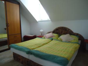sypialnia z łóżkiem z zieloną i żółtą pościelą w obiekcie Apartment Duhová we Franciszkowych Łaźniach