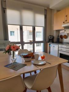 una cocina con una mesa de madera y un jarrón de flores en Apartamento Lita, en Posada de Llanes
