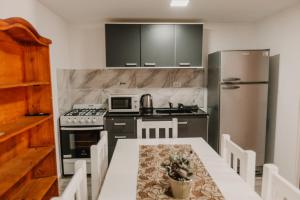 uma cozinha com uma mesa, um fogão e um frigorífico em Boulevard Duplex em General Pico