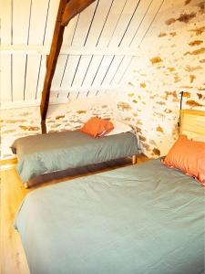 two beds in a small room with a roof at Le Cinquante in Groix