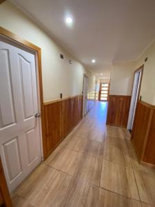 un couloir vide avec du parquet et une porte dans l'établissement Casa de Campo, à Osorno