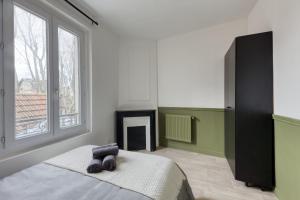 1 dormitorio con 1 cama y chimenea en Beautiful apartment - Cozy - Near Paris, en LʼÎle-Saint-Denis