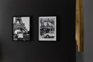 dos cuadros enmarcados de la torre Eiffel en una pared en Beautiful apartment - Cozy - Near Paris, en LʼÎle-Saint-Denis