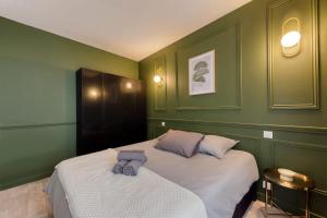 2 Betten in einem Zimmer mit grünen Wänden in der Unterkunft Charming accommodation - Close to Paris in LʼÎle-Saint-Denis