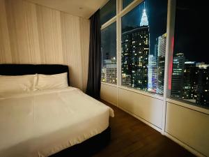 a bedroom with a bed and a window with a city skyline at Vortex Suites KLCC By Paradise IN Kuallampur City in Kuala Lumpur