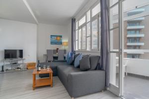 een woonkamer met een bank en een tafel bij Duas Torres View Apartment in Funchal