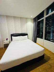 a bedroom with a large white bed and a window at Vortex Suites KLCC By Paradise IN Kuallampur City in Kuala Lumpur