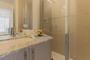 a bathroom with a shower and a sink and a mirror at Rozenhaus Hotel - Downtown Montreal in Montreal +46 photos