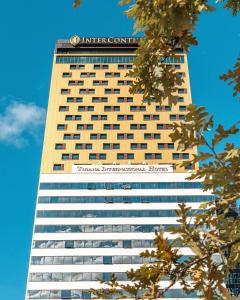 ein hohes Gebäude mit einem Schild darüber in der Unterkunft Tirana International Hotel & Conference Center in Tirana