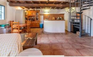 een woonkamer met een tafel en een keuken bij Casa Rural La Escuela in Arcos de la Frontera