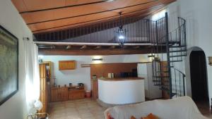 een keuken met een wenteltrap in een woonkamer bij Casa Rural La Escuela in Arcos de la Frontera