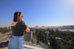 a woman standing on top of a building looking at the city at WOW Pyramids Inn in Cairo