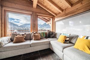 a living room with a couch and a large window at Chalet Heavenly Morzine - by EMERALD STAY in Montriond
