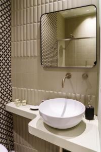a bathroom with a white sink and a mirror at Le Volte And Suite in Catania